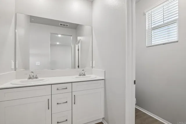 a bathroom with a double vanity sink and mirror