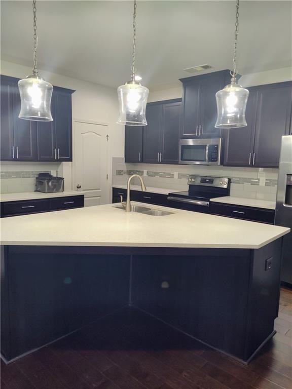 7736 Rutgers Circle Fairburn, GA 30213 - Photo 24 of 39 a kitchen with kitchen island granite countertop a sink a counter top space appliances and cabinets