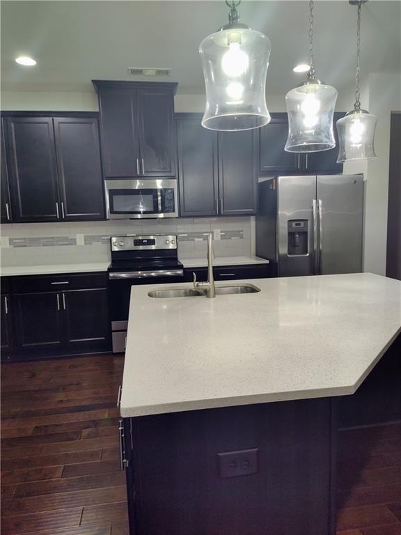 7736 Rutgers Circle Fairburn, GA 30213 - Photo 29 of 39 a kitchen with kitchen island granite countertop a sink cabinets and stainless steel appliances