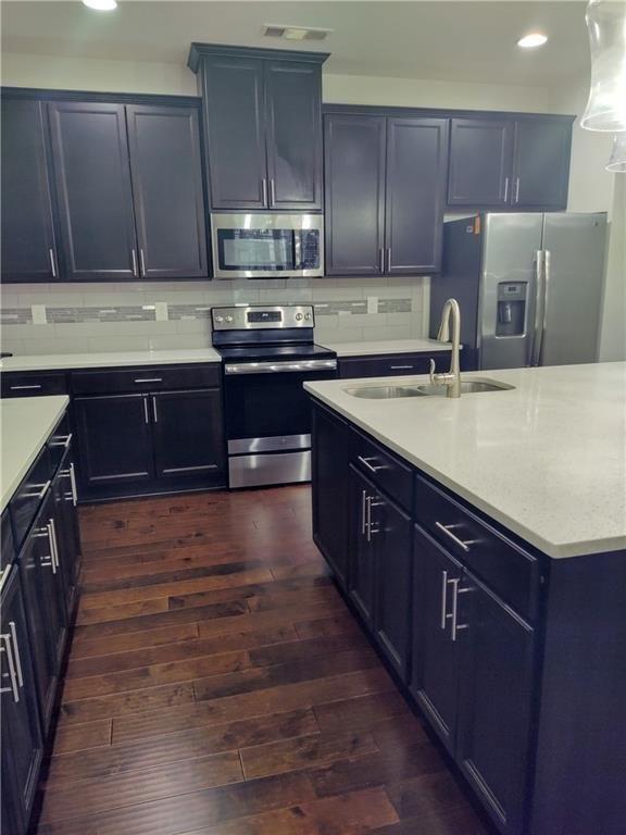 7736 Rutgers Circle Fairburn, GA 30213 - Photo 6 of 39 a kitchen with stainless steel appliances granite countertop wooden cabinets a stove top oven a sink and dishwasher