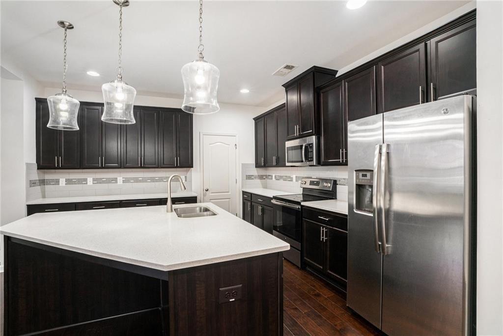 7736 Rutgers Circle Fairburn, GA 30213 - Photo 10 of 39 a kitchen with kitchen island a sink stainless steel appliances and cabinets