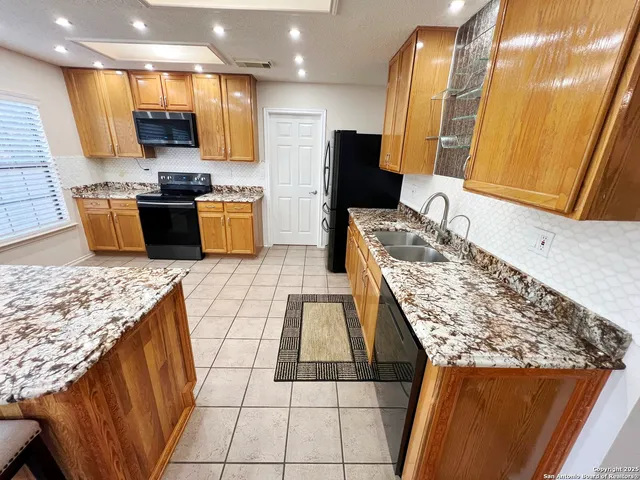 a kitchen with stainless steel appliances granite countertop a sink and a stove