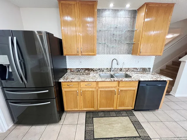 a kitchen with granite countertop a refrigerator and a sink