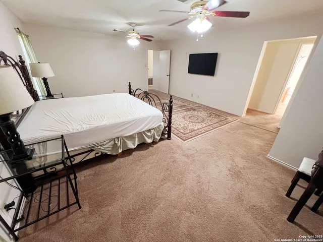 a spacious bedroom with a bed and a flat screen tv