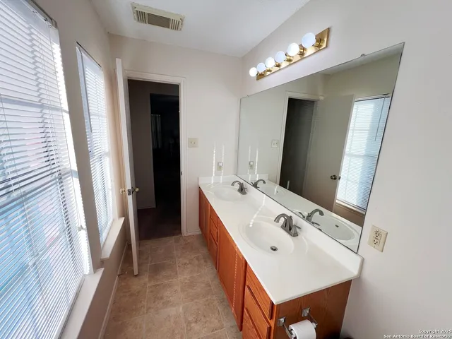 a bathroom with a double vanity sink and mirror