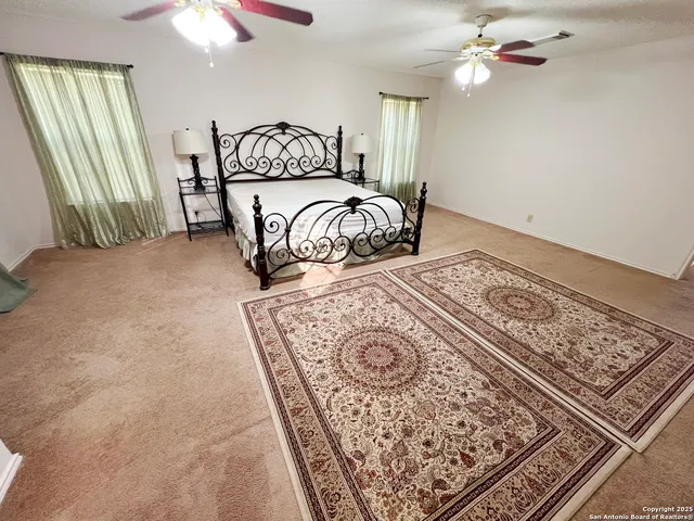 a bedroom with a large bed and a chandelier