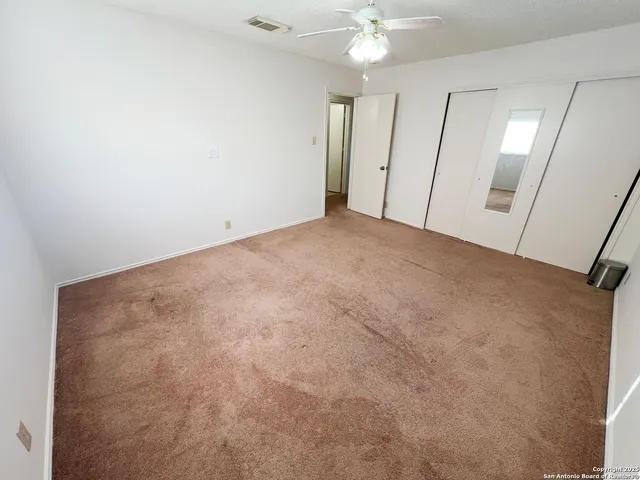 an empty room with a chandelier fan