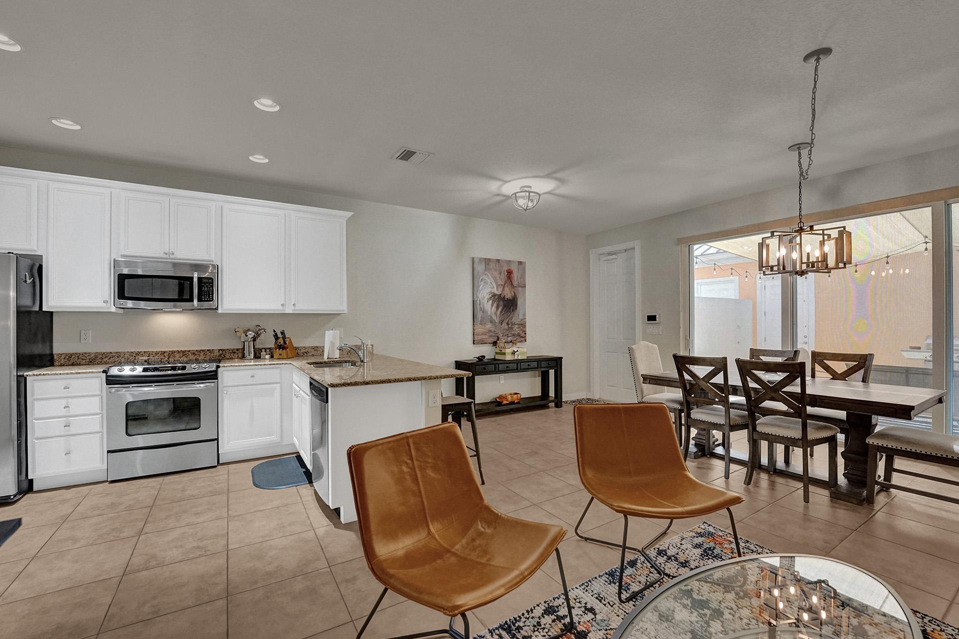 1172 Islamorada Drive Jupiter, FL 33458 - Photo 15 of 42 a kitchen with stainless steel appliances kitchen island granite countertop a stove a sink a dining table and chairs
