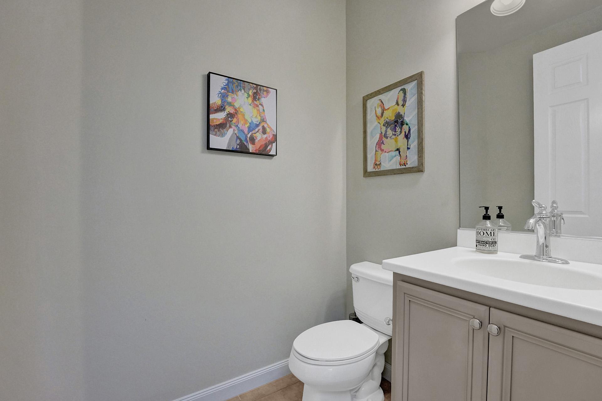 1172 Islamorada Drive Jupiter, FL 33458 - Photo 18 of 42 a bathroom with a toilet a sink and mirror