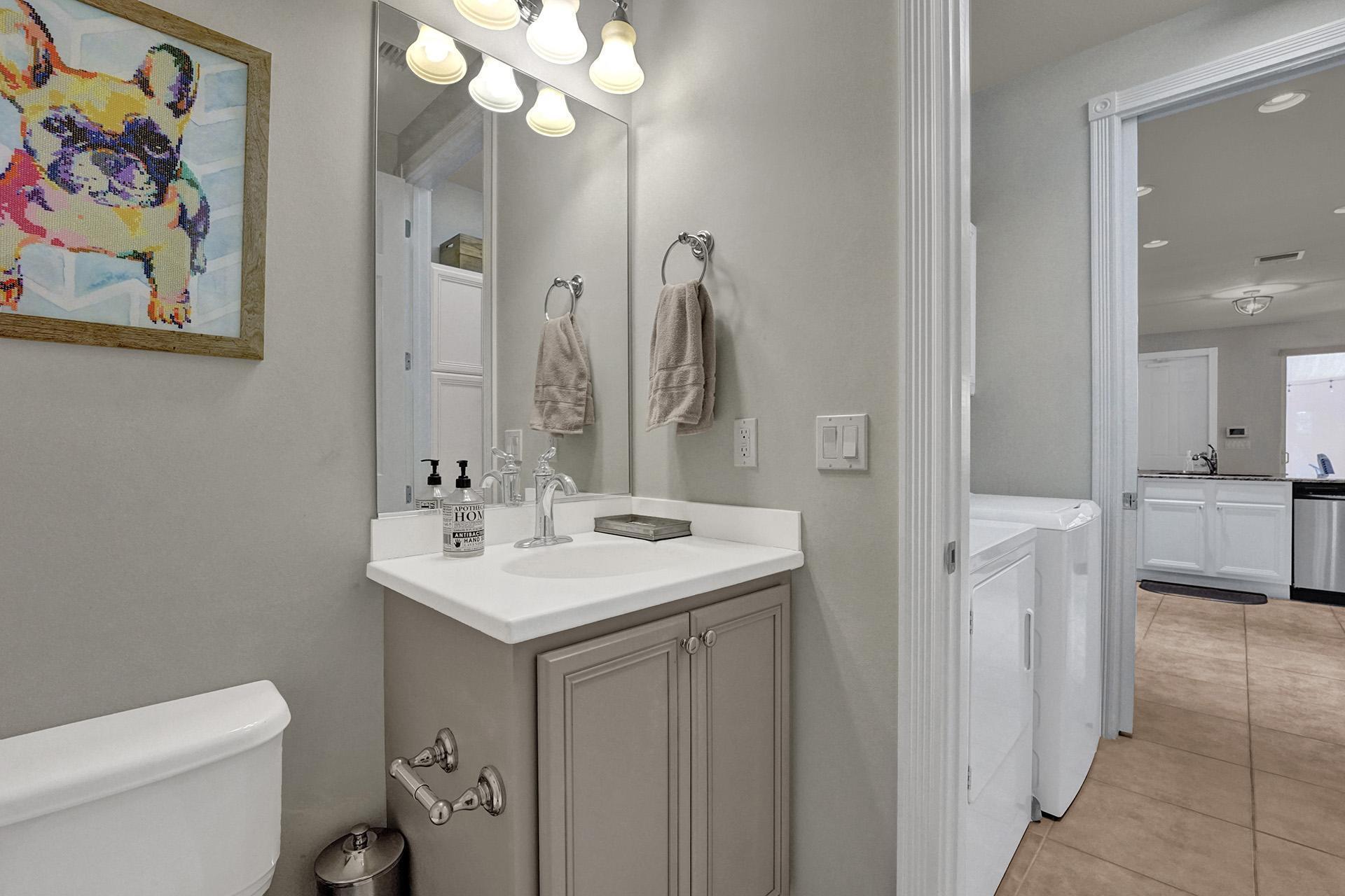 1172 Islamorada Drive Jupiter, FL 33458 - Photo 19 of 42 a bathroom with a sink a toilet and a mirror