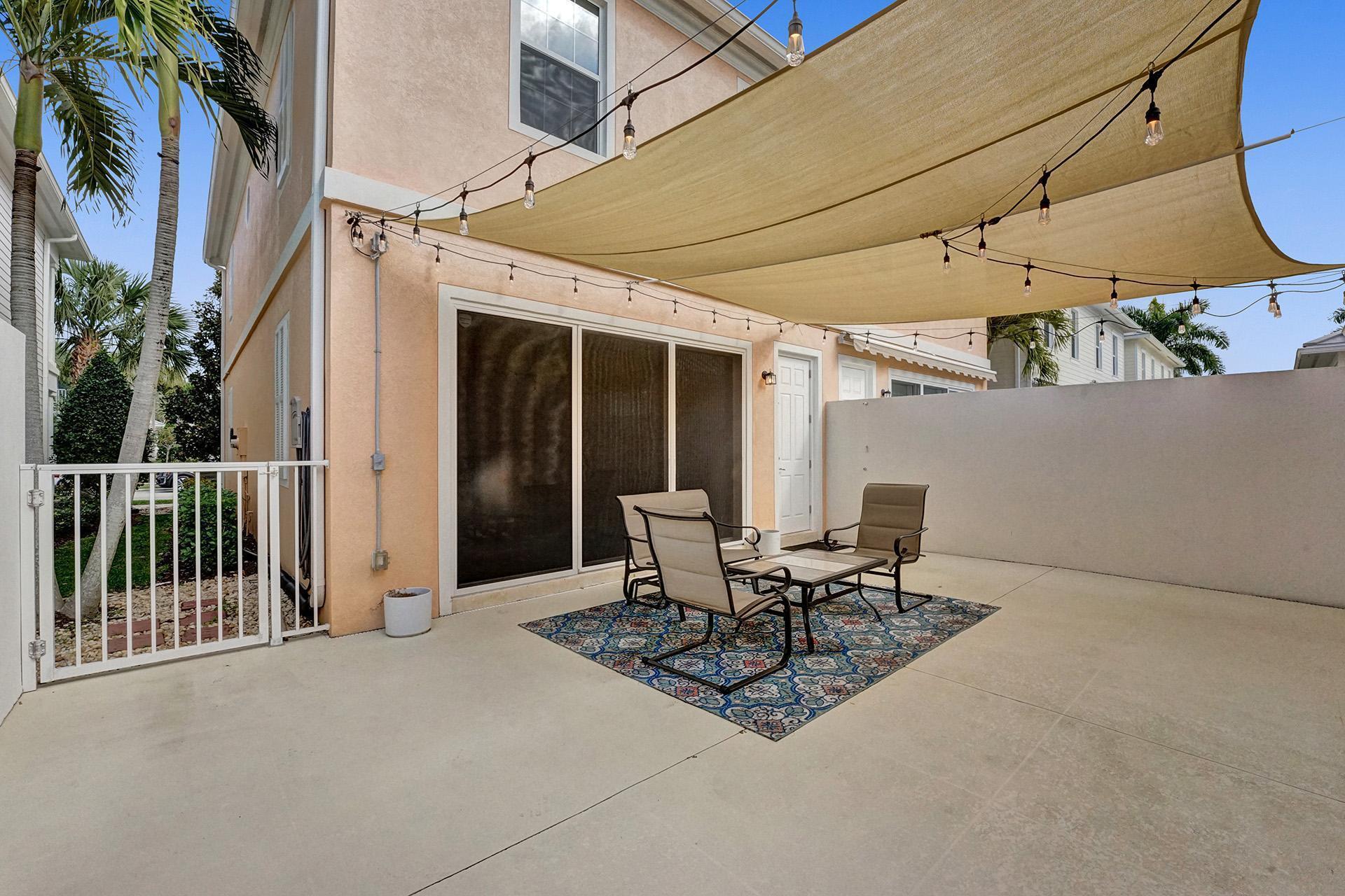 1172 Islamorada Drive Jupiter, FL 33458 - Photo 22 of 42 a view of a patio with table and chairs and potted plants