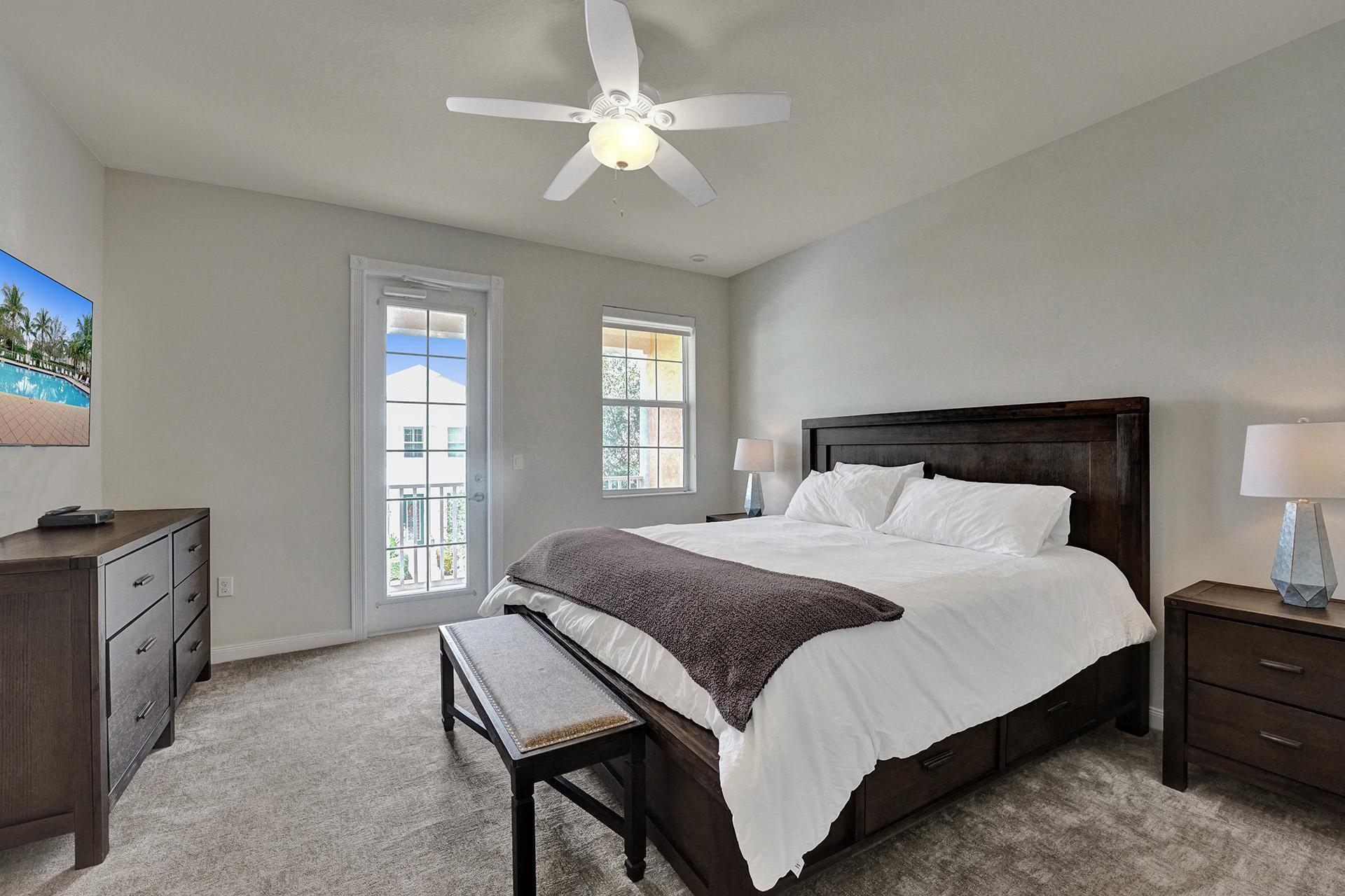 1172 Islamorada Drive Jupiter, FL 33458 - Photo 25 of 42 a bedroom with a large bed and a chandelier