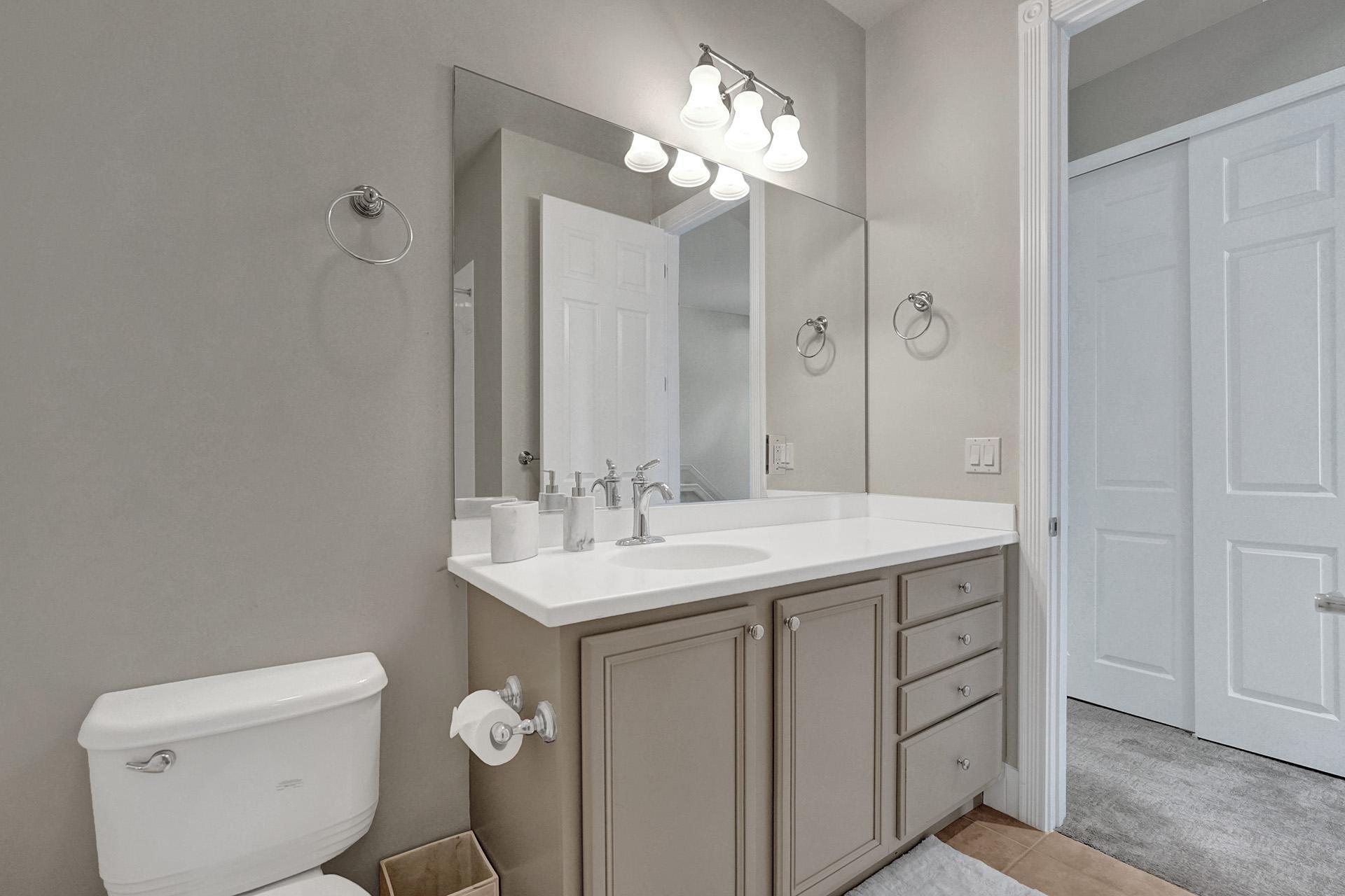 1172 Islamorada Drive Jupiter, FL 33458 - Photo 36 of 42 a bathroom with a toilet sink and mirror