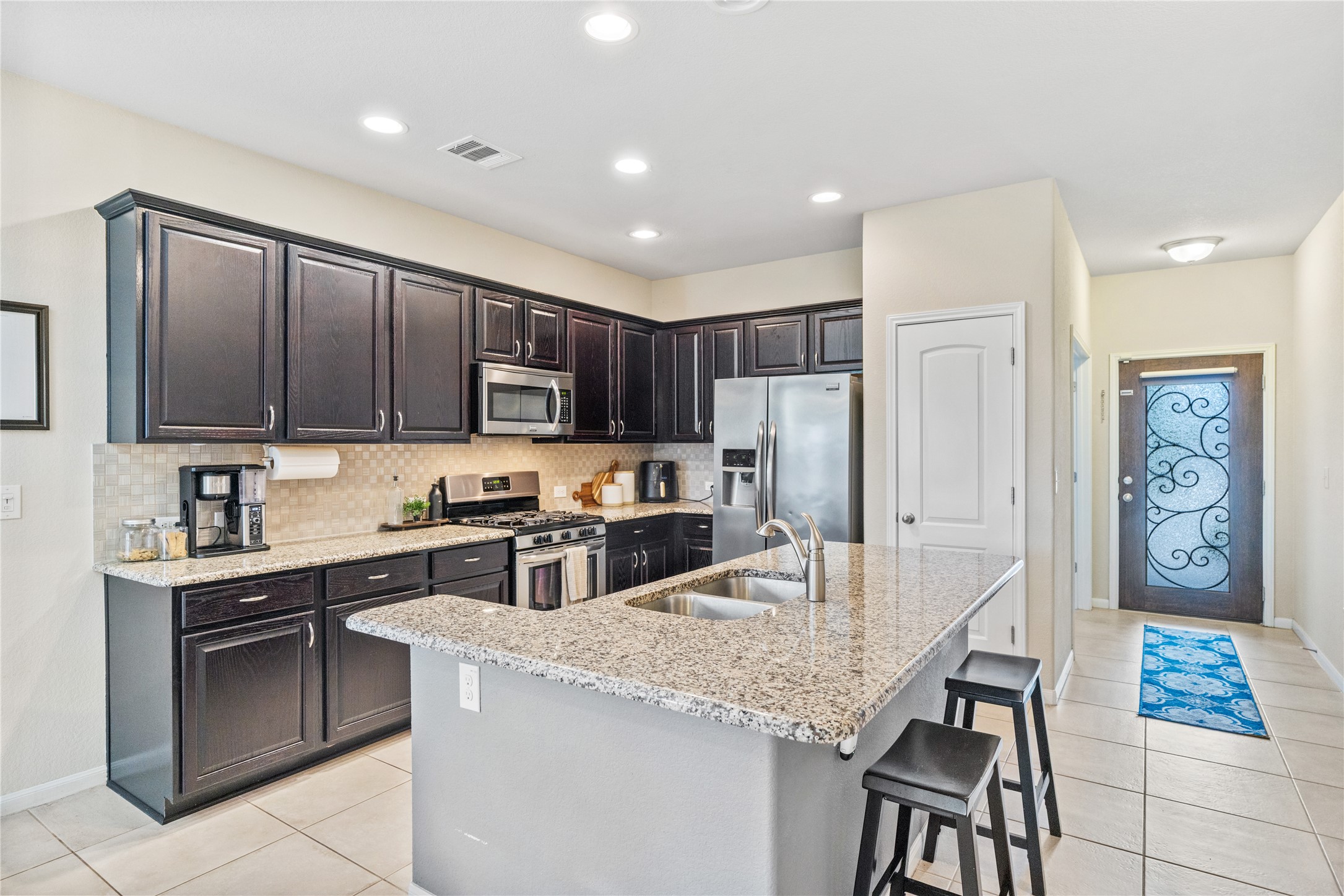 116 Cypress Bend Court Georgetown, TX 78626 - Photo 3 of 35 a kitchen with stainless steel appliances granite countertop a stove top oven a sink dishwasher and a refrigerator with wooden floor
