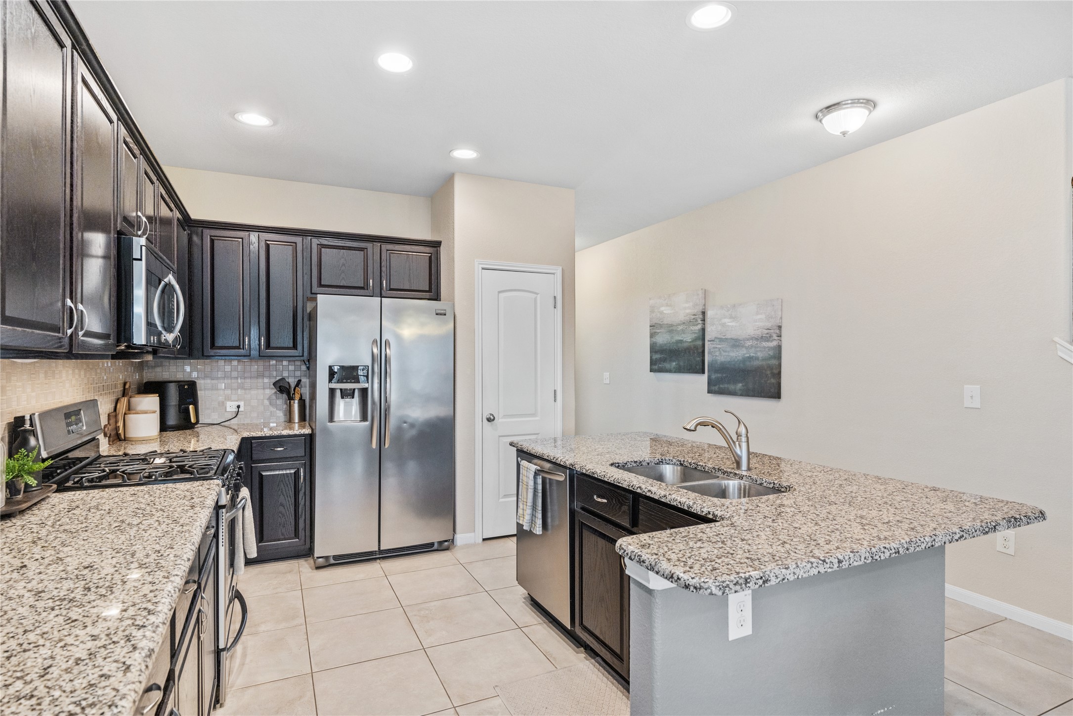 116 Cypress Bend Court Georgetown, TX 78626 - Photo 4 of 35 a kitchen with stainless steel appliances granite countertop a sink stove and refrigerator
