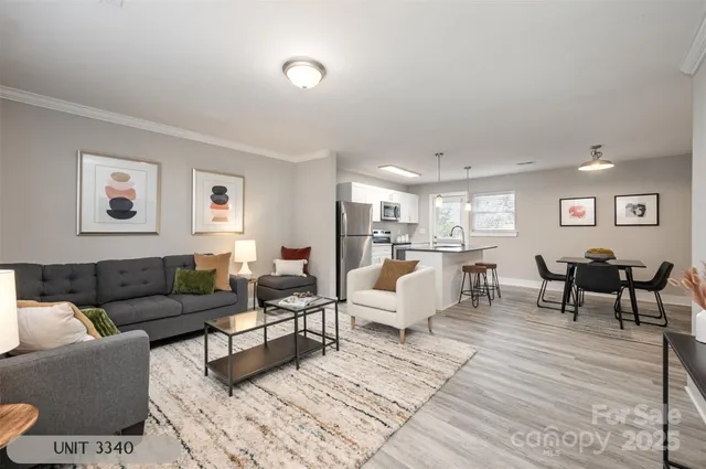 a living room with furniture and view of kitchen
