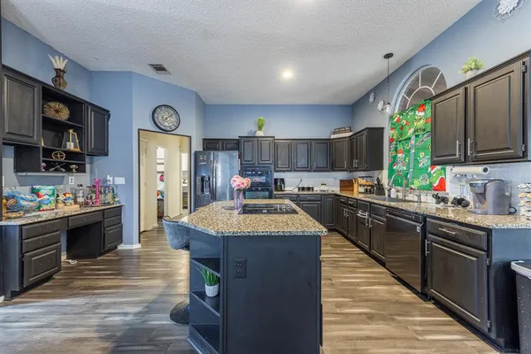 a kitchen with stainless steel appliances kitchen island granite countertop a sink and cabinets