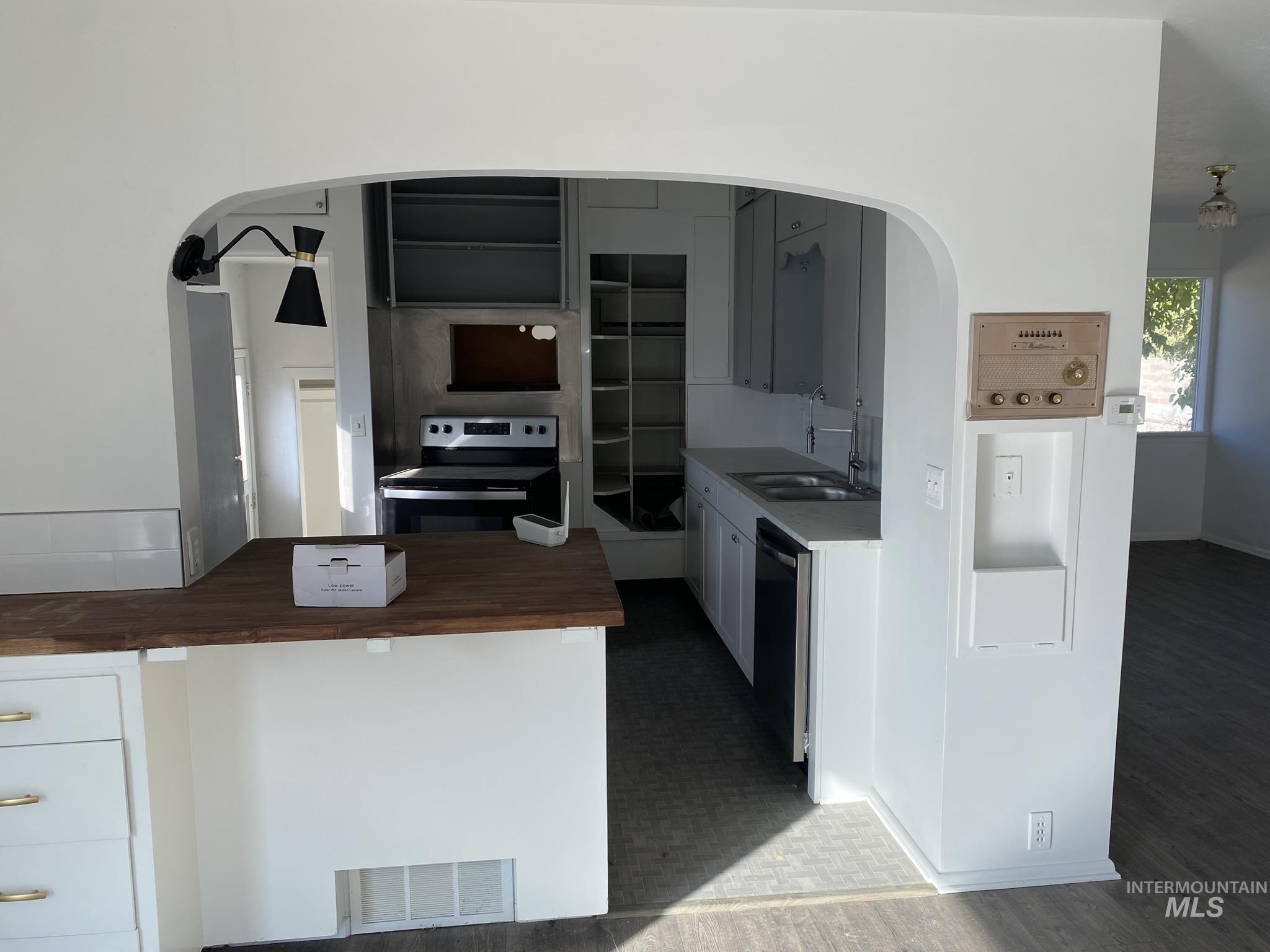 1967 North Fry Street Boise, ID 83704 - Photo 4 of 15 Kitchen featuring appliances with stainless steel finishes, white cabinets, arched walkways, and wood counters