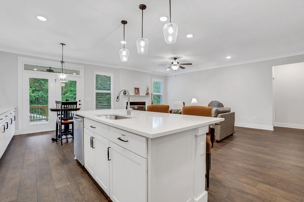 413 Solace Place Canton, GA 30114 - Photo 18 of 75 a large white kitchen with a large island oven a stove and a wooden floors