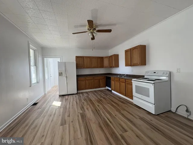 a kitchen with wooden floors and appliances