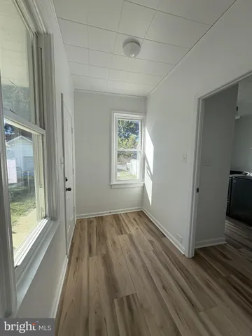 a view of hallway with a large window and wooden floor