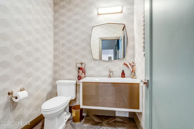 a bathroom with a toilet sink and mirror