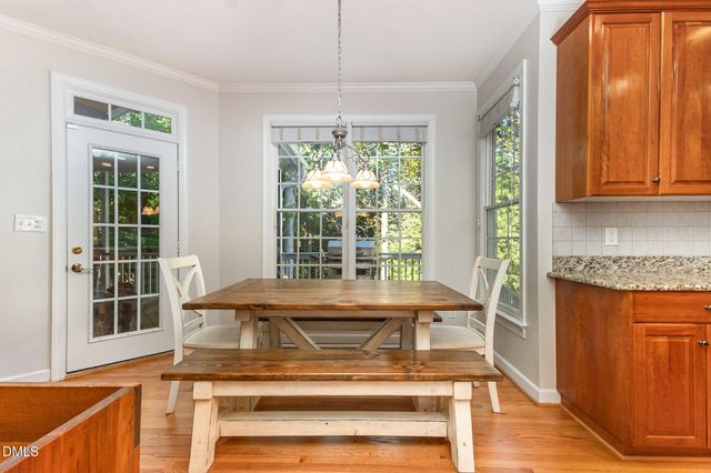 a kitchen with stainless steel appliances granite countertop a refrigerator a sink dishwasher and wooden cabinets with wooden floor