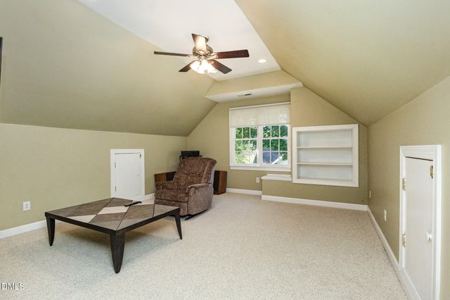 a view of a patio with table and chairs potted plants and floor to ceiling window