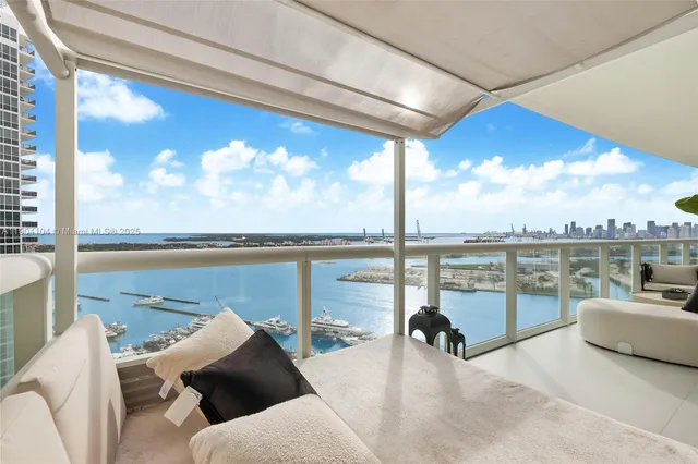 a view of a balcony with dining table and chairs