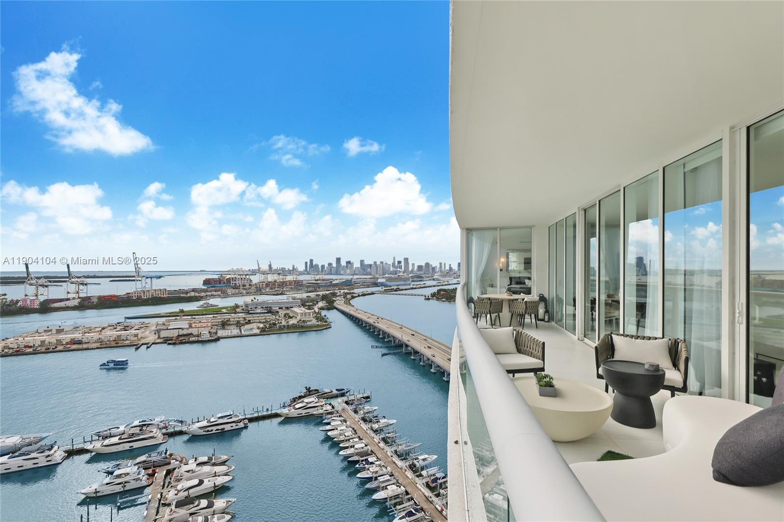 450 Alton Road, Unit 2603 Miami Beach, FL 33139 - Photo 14 of 64 a view of a balcony with dining table and chairs