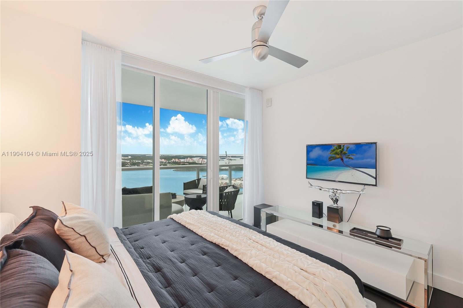 450 Alton Road, Unit 2603 Miami Beach, FL 33139 - Photo 25 of 64 a bedroom with a bed a large window and walk in closet