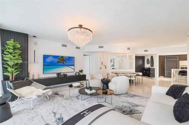 a living room with furniture chandelier and a large window