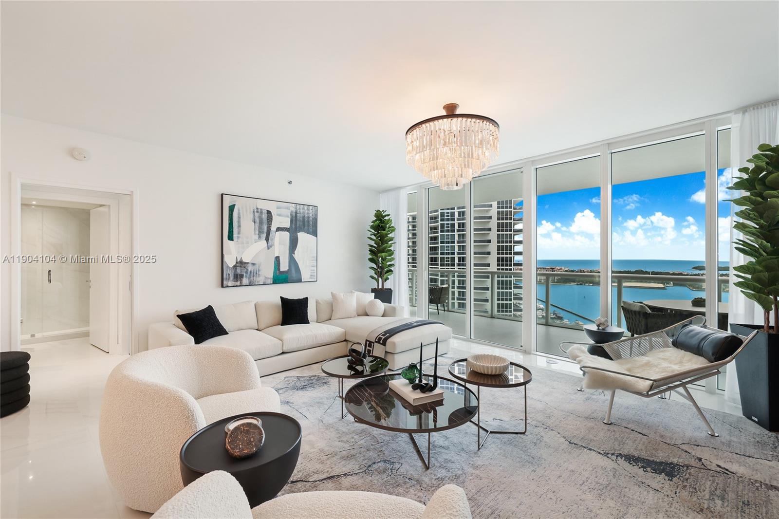 450 Alton Road, Unit 2603 Miami Beach, FL 33139 - Photo 9 of 64 a living room with furniture chandelier and a large window