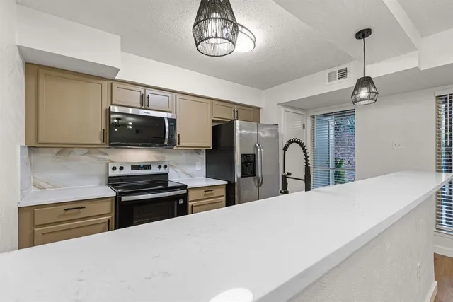 a kitchen with stainless steel appliances a stove microwave and a refrigerator