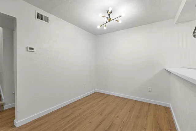 a view of a room with wooden floor and a window