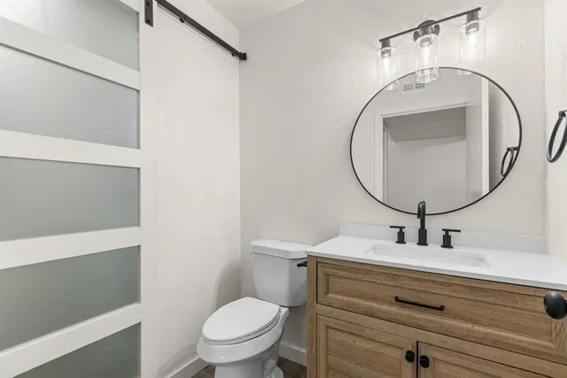 a bathroom with a sink mirror vanity and toilet