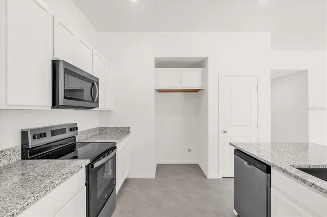 a kitchen with granite countertop a sink and a stove top oven with wooden floor