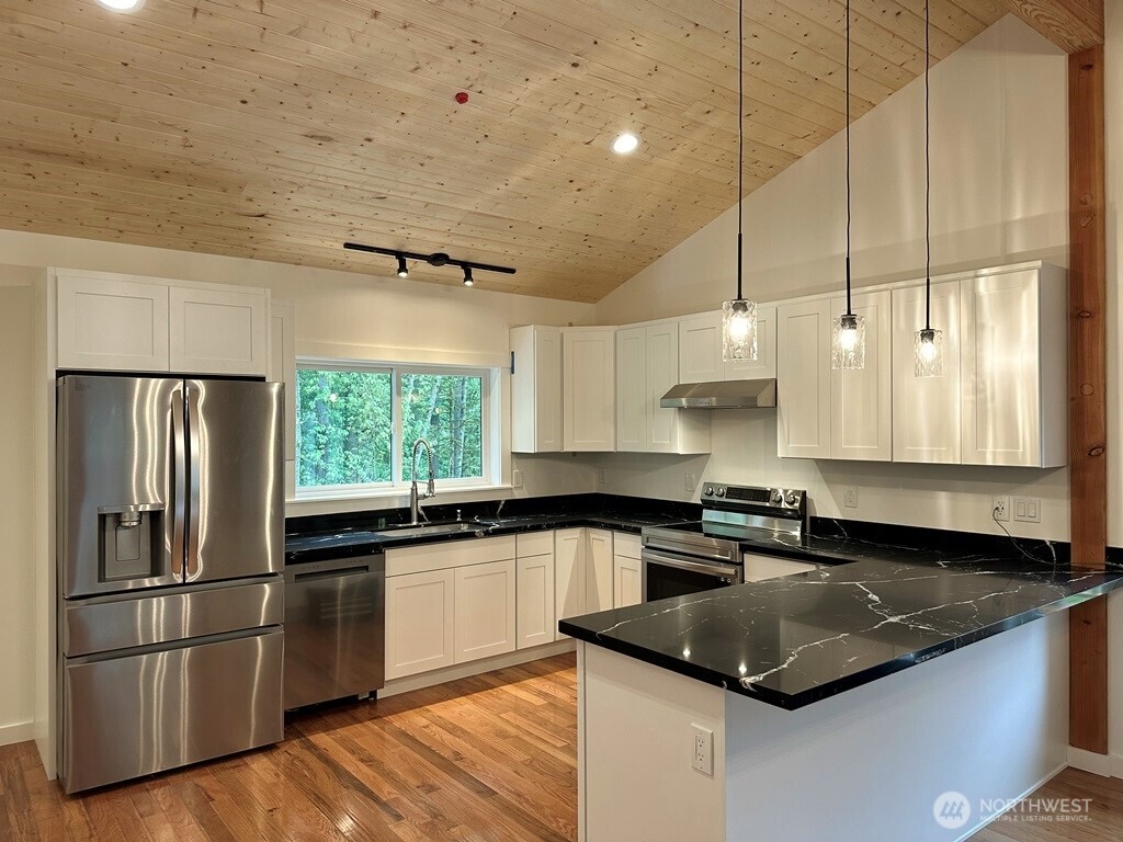 24345 Wax Orchard Road Southwest Vashon, WA 98070 - Photo 5 of 17 a kitchen with stainless steel appliances granite countertop a sink a stove and a refrigerator