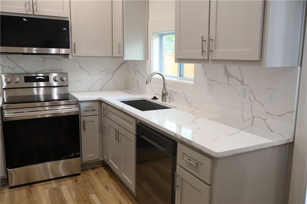 5120 Railroad Avenue Flowery Branch, GA 30542 - Photo 15 of 34 a kitchen with stainless steel appliances granite countertop a sink and a stove