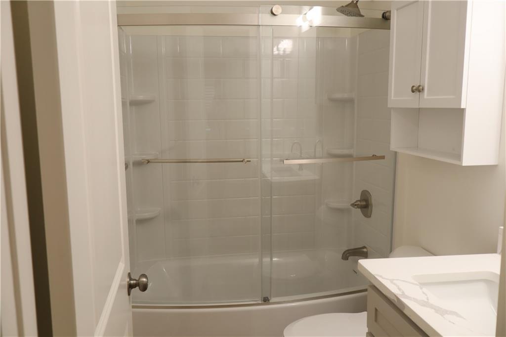 5120 Railroad Avenue Flowery Branch, GA 30542 - Photo 9 of 34 a bathroom with a granite countertop bathtub shower and toilet