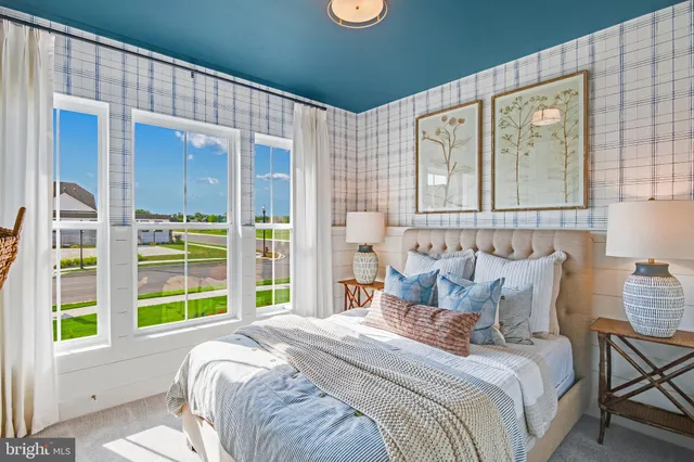 a bedroom with a bed and a large window