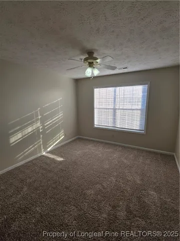 en empty room with windows and ceiling fan view