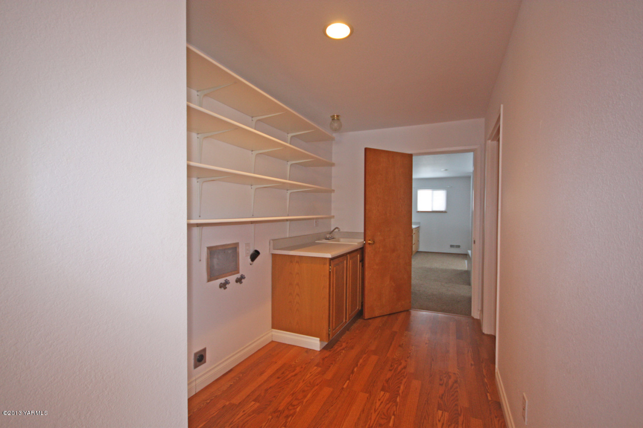 7303 Bittner Road Yakima, WA 98901 - Photo 17 of 38 a view of a hallway with wooden floor and a bathroom