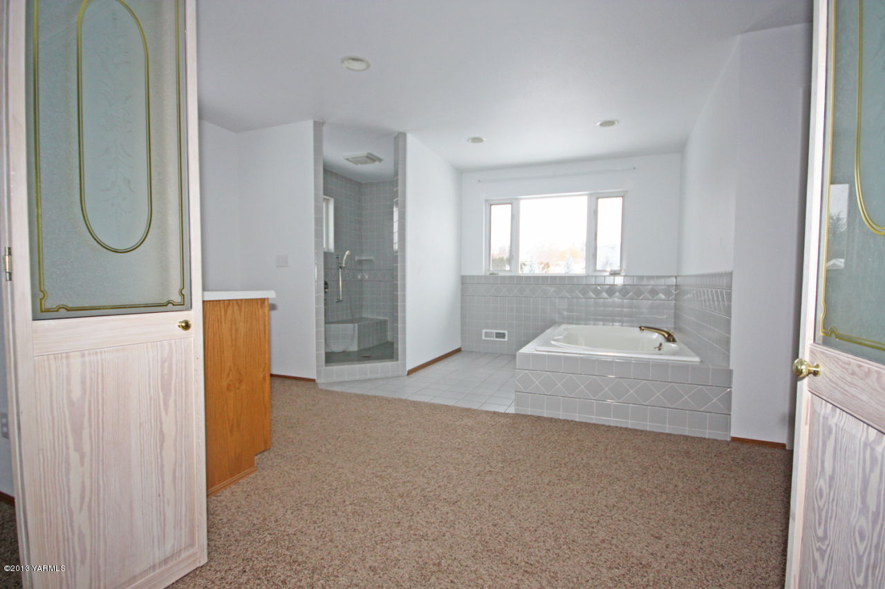 7303 Bittner Road Yakima, WA 98901 - Photo 23 of 38 a bathroom with a granite countertop bathtub shower sink and mirror