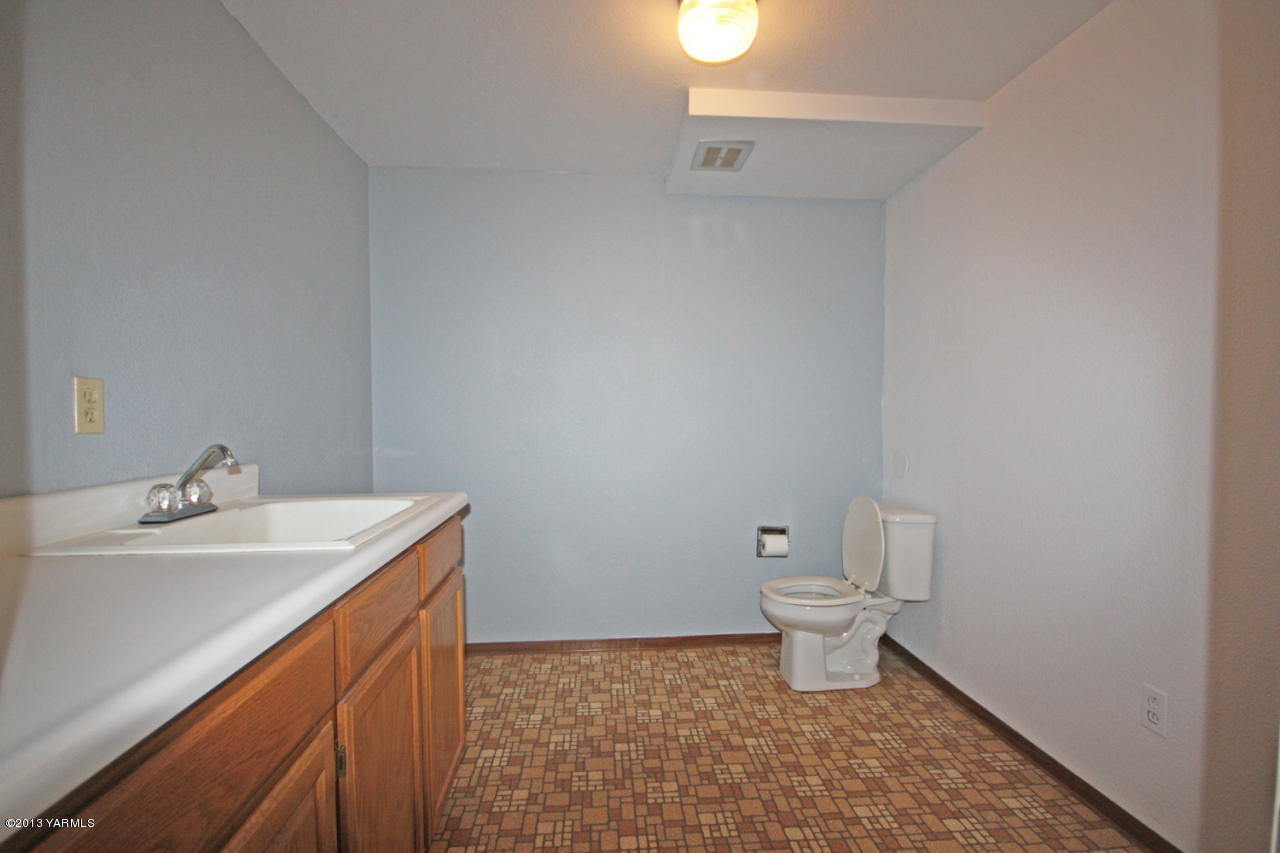 7303 Bittner Road Yakima, WA 98901 - Photo 36 of 38 a bathroom with a sink a toilet and a mirror