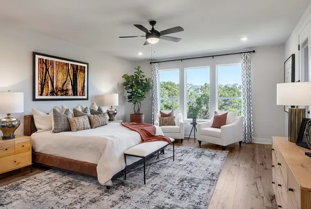 a living room with furniture a flat screen tv and a floor to ceiling window