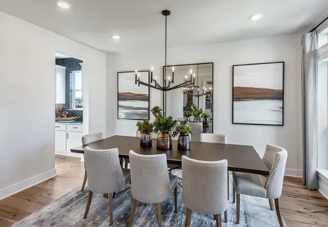 a living room with furniture a rug and wall paintings