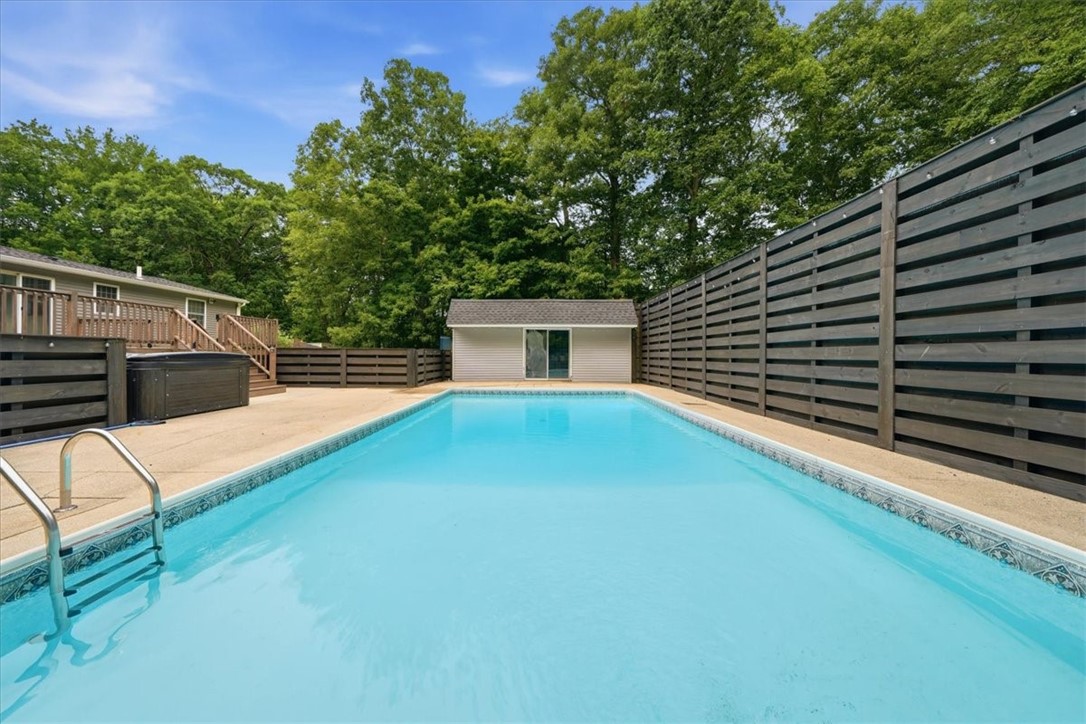 214 Anan Wade Road Glocester, RI 02857 - Photo 36 of 50 Your own private retreat—this 17' x 35' in-ground saltwater pool is surrounded by patio space, an impressive 10-ft privacy fence and a beautiful wooded backdrop. Relax year-round in the newer 6-person hot tub, added in 2022.