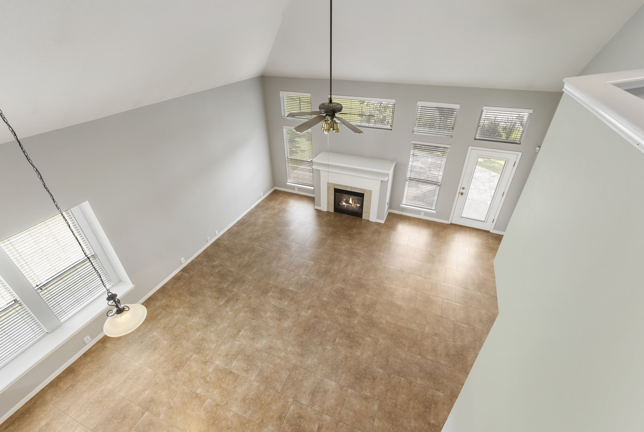 2907 Stemwood Drive Spring, TX 77388 - Photo 26 of 33 Open-to-below living area showcasing soaring ceilings, a statement fireplace, and expansive windows that fill the space with natural light while overlooking the waterfront backyard and patio.