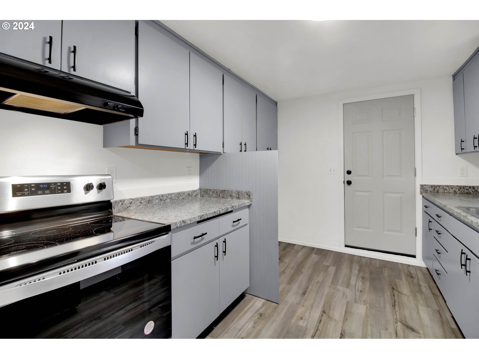 2224 Ohio Street Eugene, OR 97402 - Photo 17 of 31 a kitchen with granite countertop a stove and a wooden floors